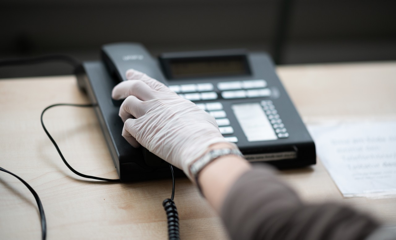 Eine ehrenamtliche Telefonseelsorgerin im Auftrag der Diakonie Hamburg greift nach einem Telefonhörer.