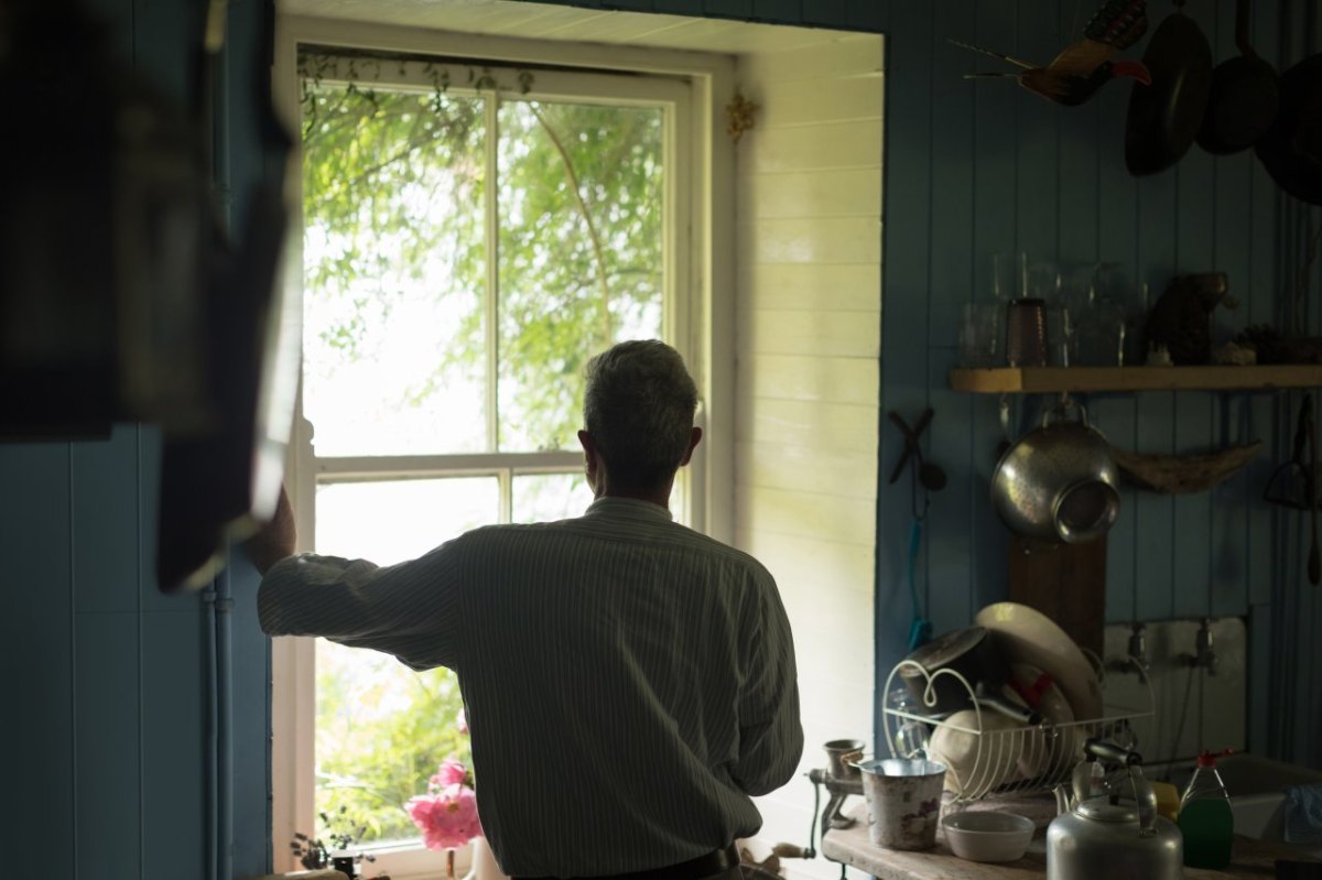 Mann schaut aus Fenster.jpg