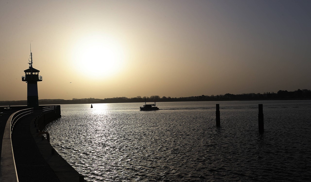 Ein Fischerboot im Sonnenaufgang vor Lübeck-Travemünde. 