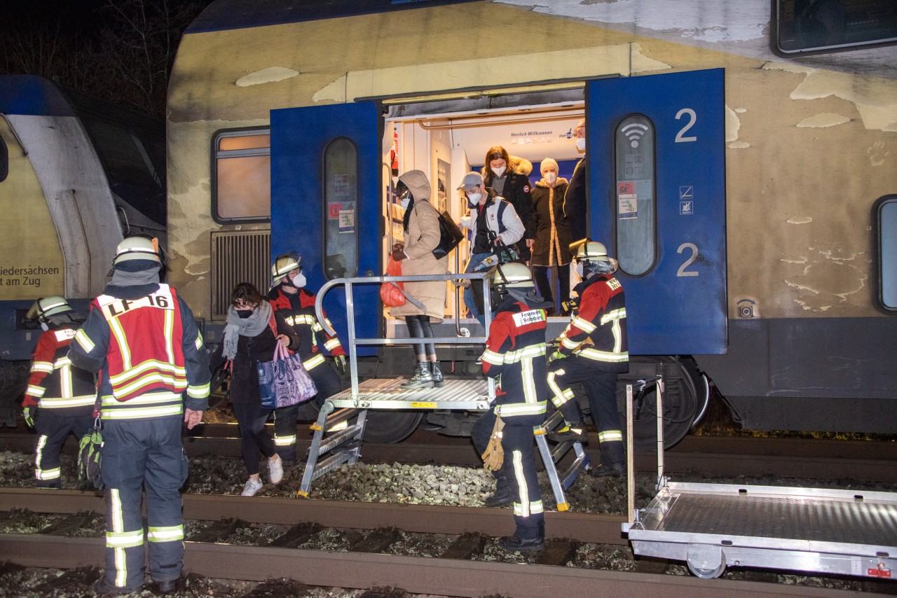 Passagiere verlassen mit der Hilfe von Feuerwehrleuten einen Nahverkehrszug, dessen Lok auf der Bahnstrecke Hamburg - Bremen mit einem Baum kollidiert war.