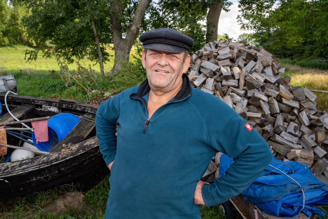 Der ehemalige Fischer Hans-Joachim Bull steht an einem Fischerboot in Lobbe auf Rügen. 