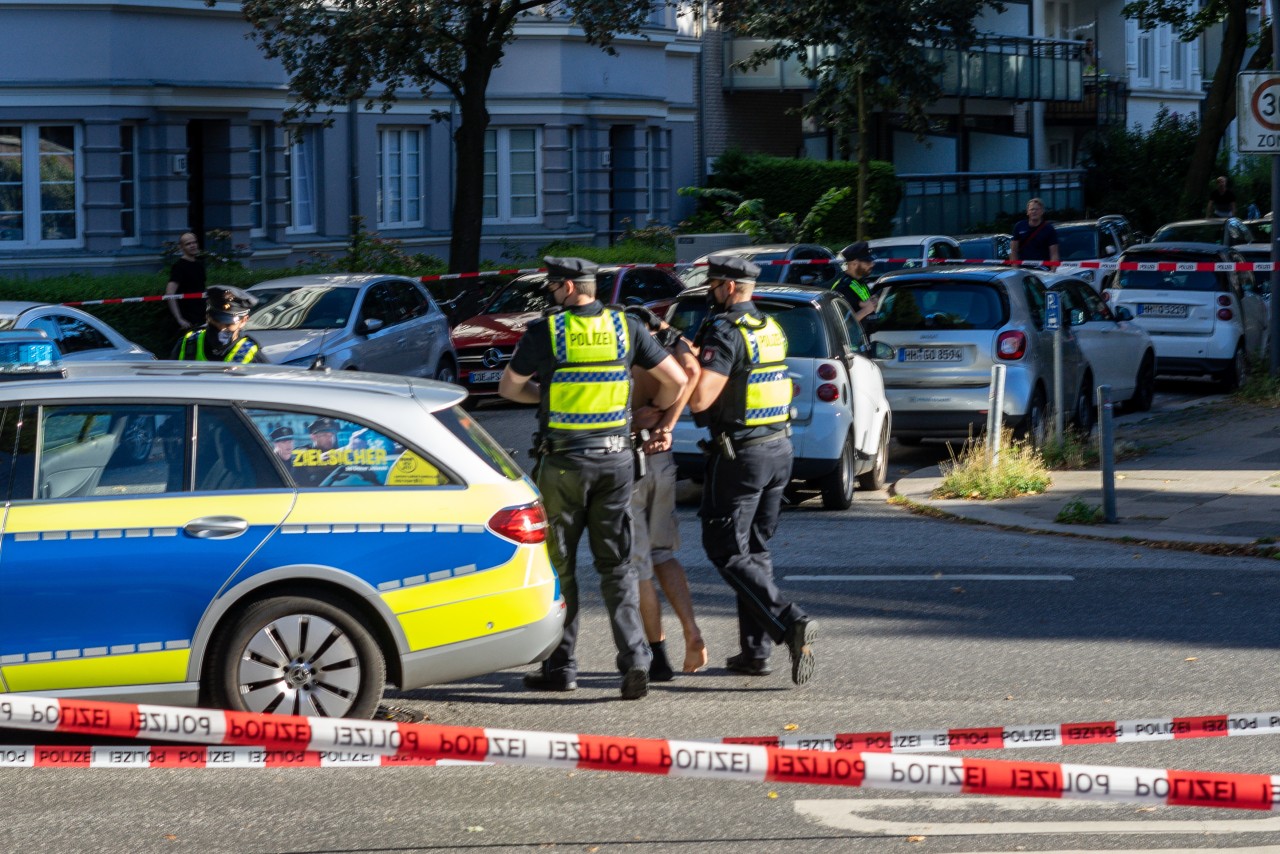 Die Polizei führt den mutmaßlichen Täter in Hamburg-Barmbek ab.
