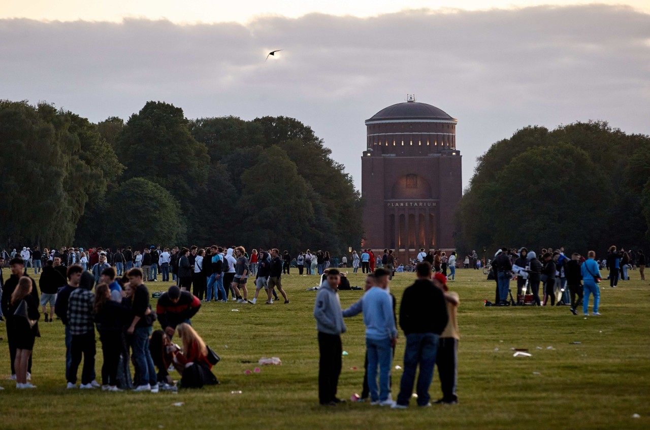 Zahlreiche Jugendliche versammeln sich im Stadtpark. Im Hintergrund ist das Planetarium zu sehen. 