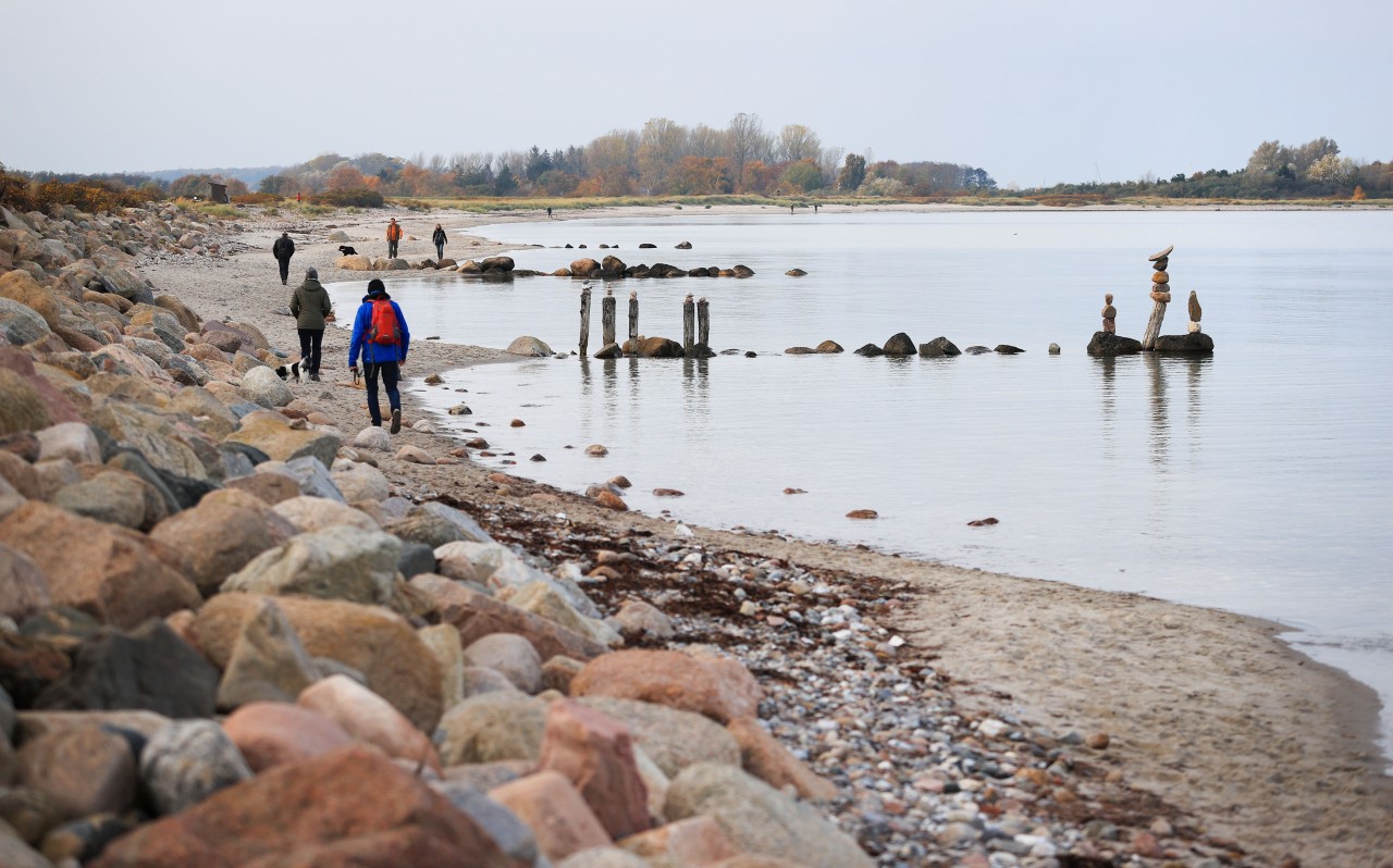 Spaziergänger sind an der Ostsee unterwegs. 