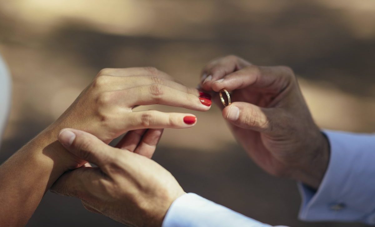 Hochzeit Bräutigam steckt Braut Ring an den Finger