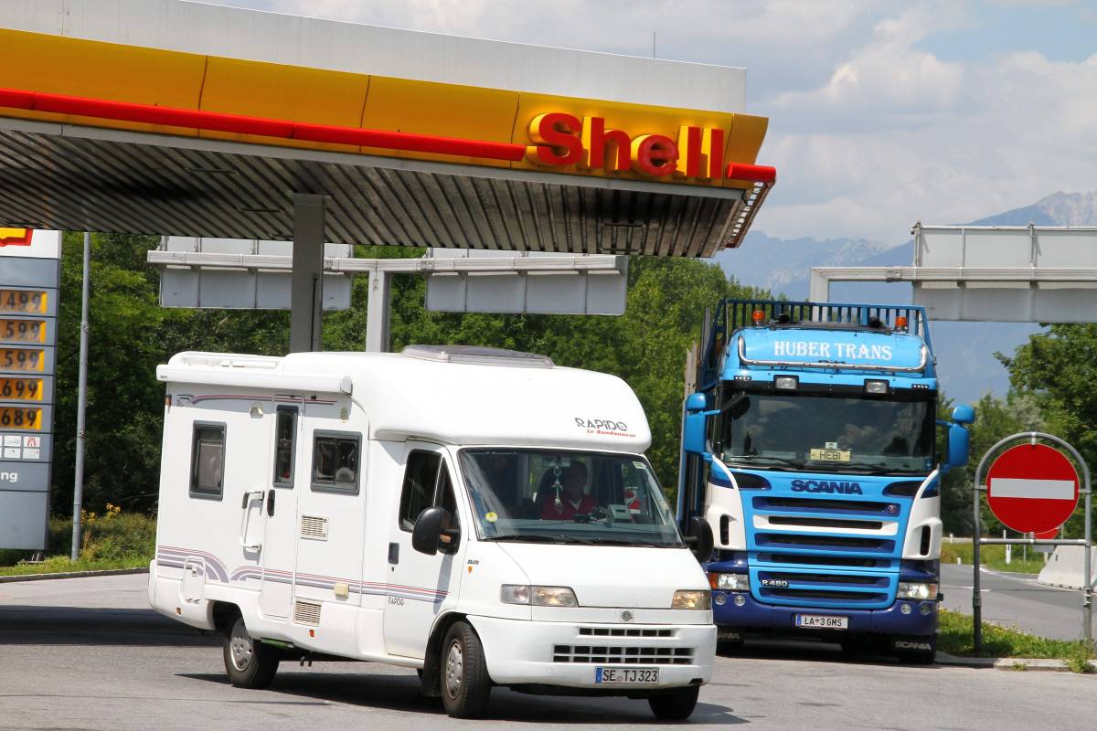 Ein Wohnmobil bei einer Tankstelle.