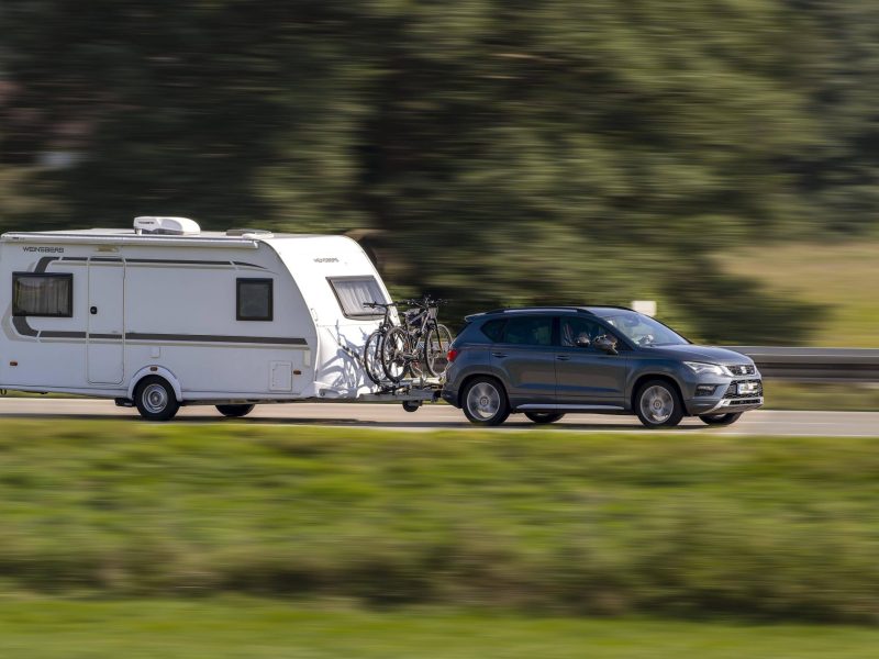 Ein Auto mit Wohnwagen auf der Autobahn.