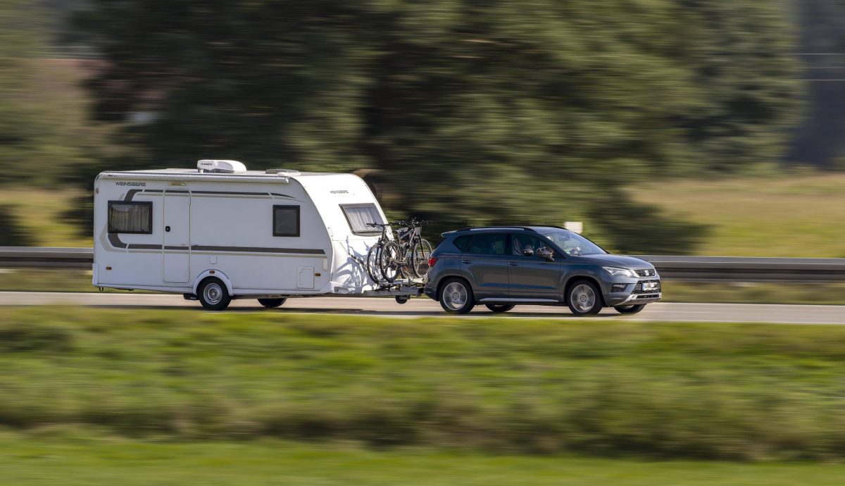 Ein Auto mit Wohnwagen auf der Autobahn.